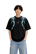 Model wearing oversized black streetwear t-shirt with blue flame graphic and baggy jeans