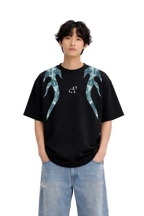 Model wearing oversized black streetwear t-shirt with blue flame graphic and baggy jeans