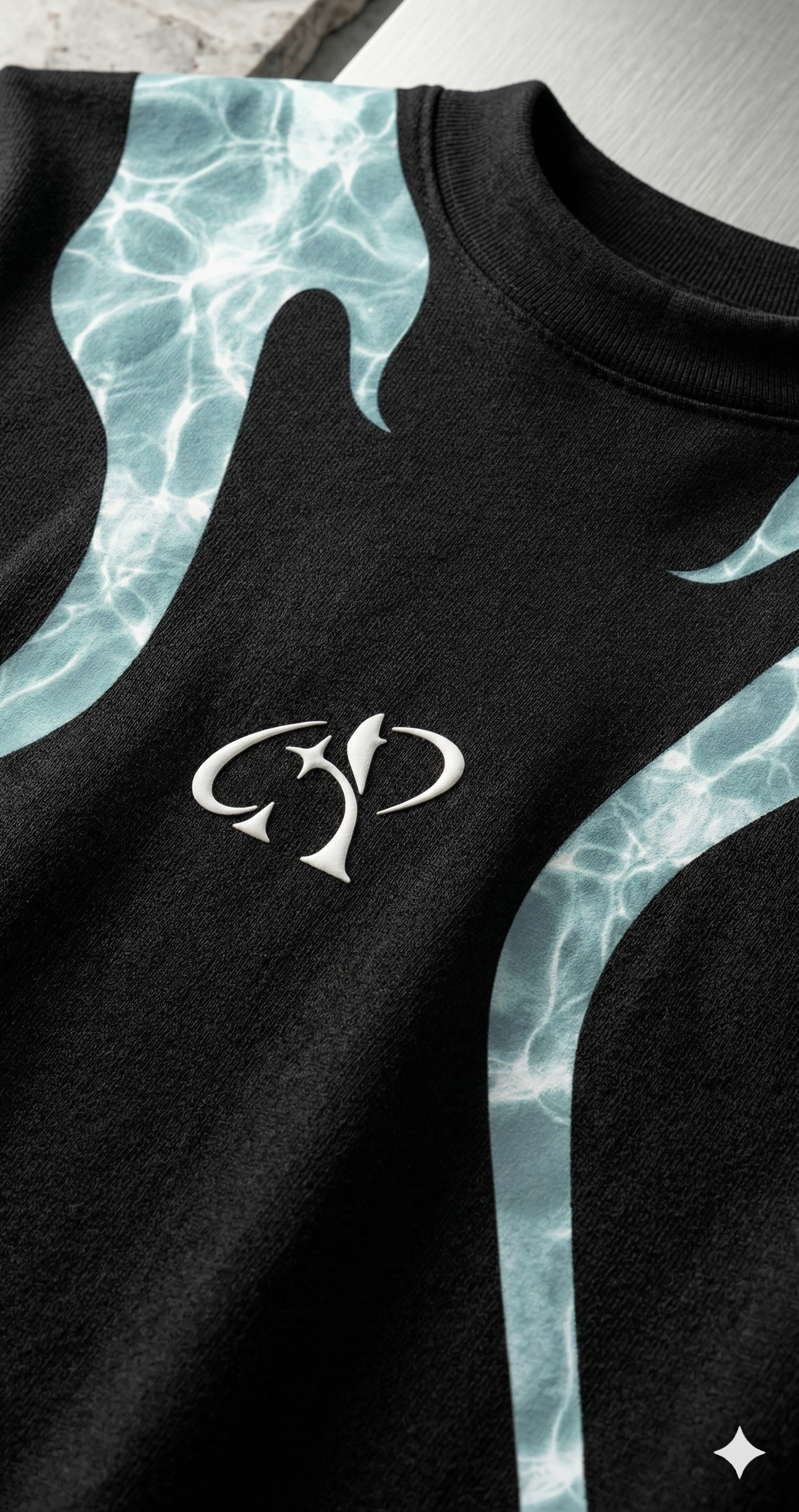 Black streetwear t-shirt with aqua flame graphic and abstract logo, close-up view.