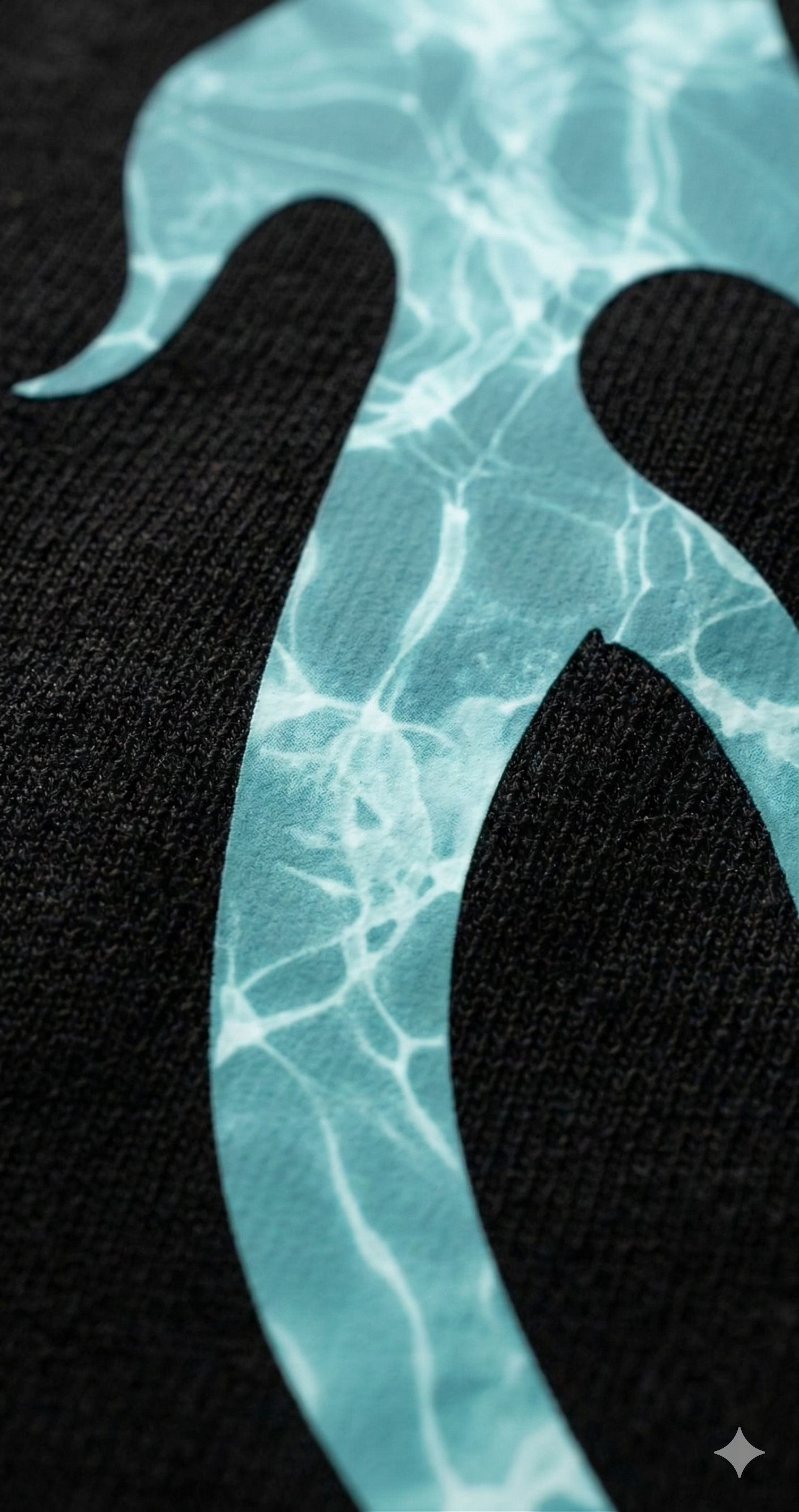 Close-up of aqua blue water-patterned graphic on black oversized streetwear t-shirt