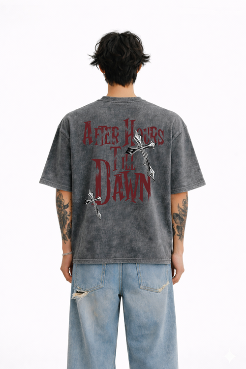 Man wearing oversized washed black streetwear t-shirt with 'After Hours Till Dawn' and cross graphics on back, paired with ripped light denim jeans.