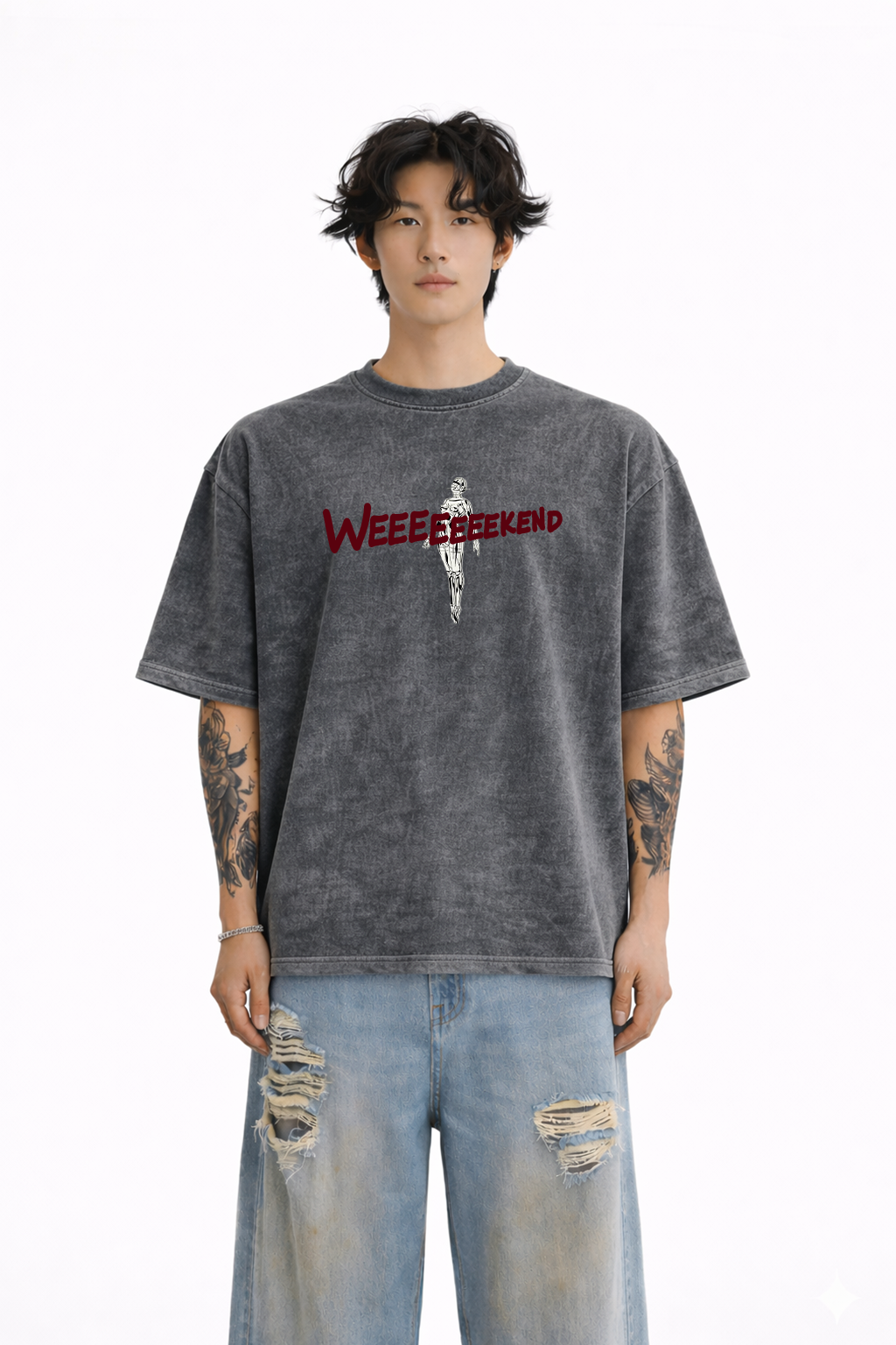 Man wearing oversized washed black t-shirt with 'WEEEEEEKEND' text and skeleton graphic, styled with ripped jeans.